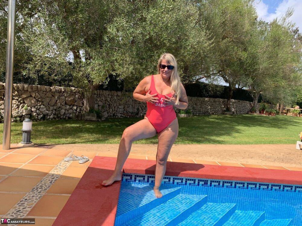 Overweight blonde Sweet Susi frees her tits and twat from a swimsuit by a pool - #10