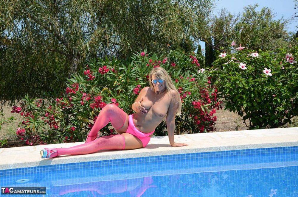 Older blonde amateur Sweet Susi shows her tits and ass beside a pool in shades - #3
