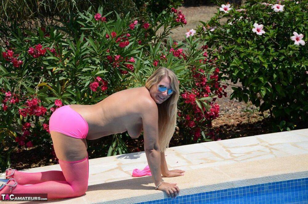 Older blonde amateur Sweet Susi shows her tits and ass beside a pool in shades - #2