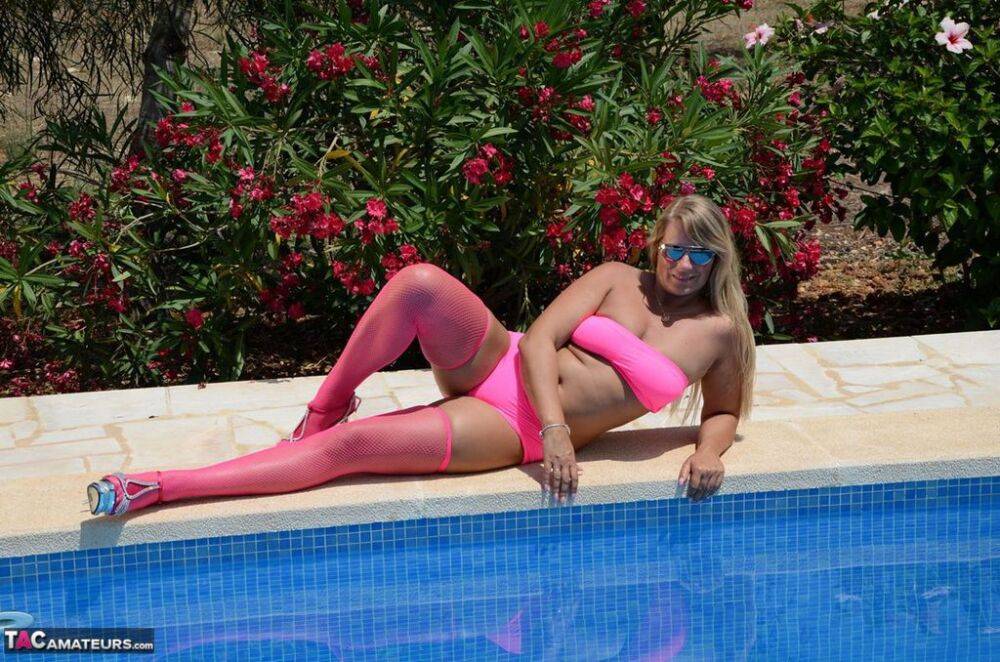 Older blonde amateur Sweet Susi shows her tits and ass beside a pool in shades - #7