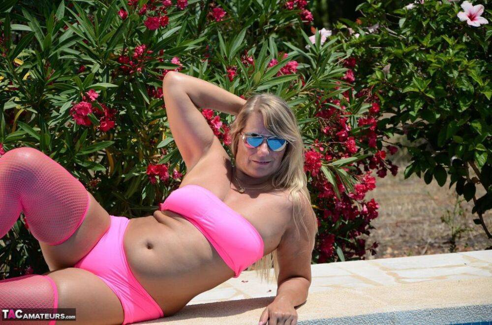 Older blonde amateur Sweet Susi shows her tits and ass beside a pool in shades - #9