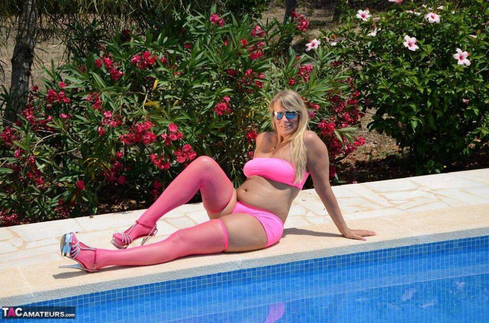 Older blonde amateur Sweet Susi shows her tits and ass beside a pool in shades - #15