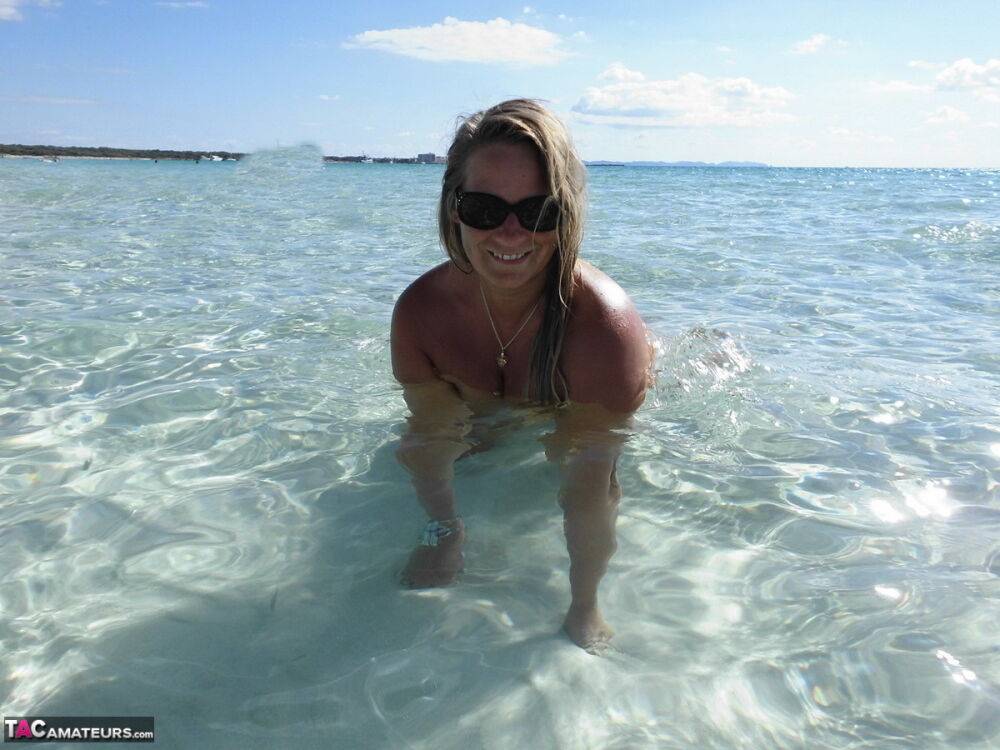 Middle-aged blonde Sweet Susi takes a dip in the ocean while completely naked - #11