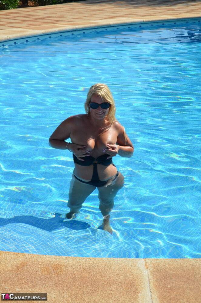 Middle-aged blonde Sweet Susi releases her boobs from a swimsuit in a pool | Photo: 1330037