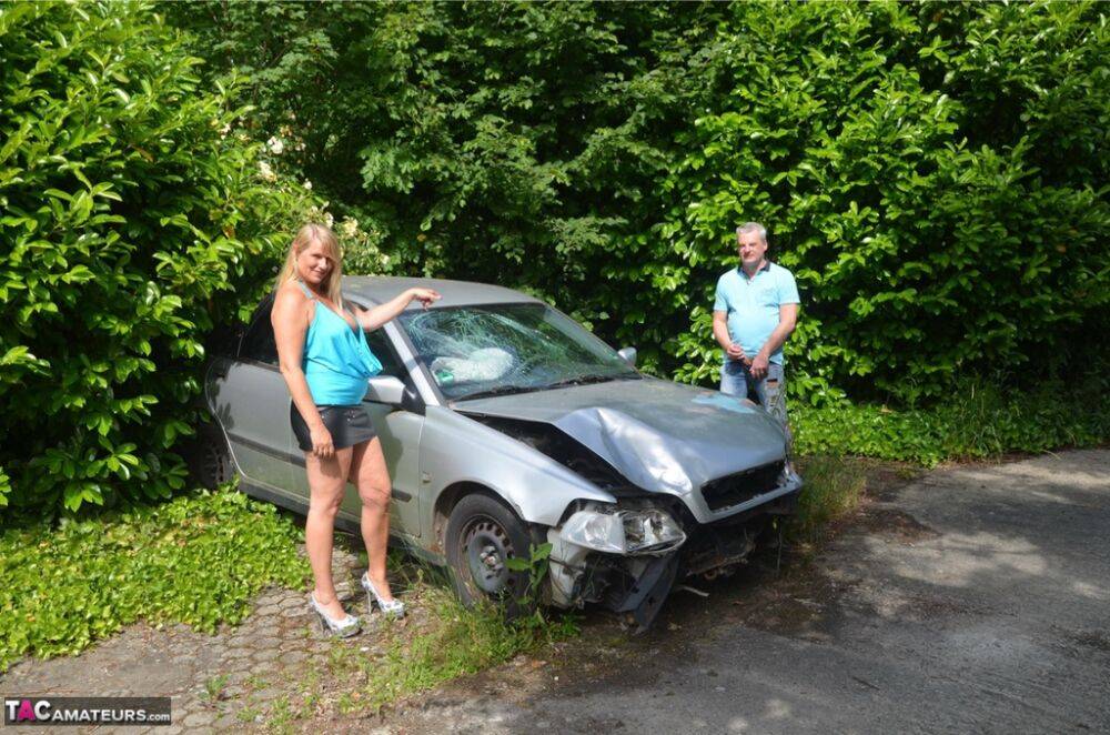 Older blonde Sweet Susi sucks a dick by a wrecked automobile in the backyard | Photo: 1330206