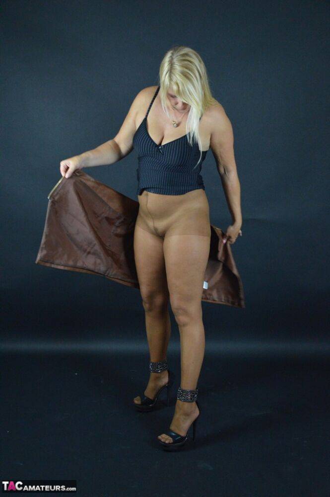 Thick blond amateur Sweet Susi takes off a leather skirt while wearing hose | Photo: 1330289