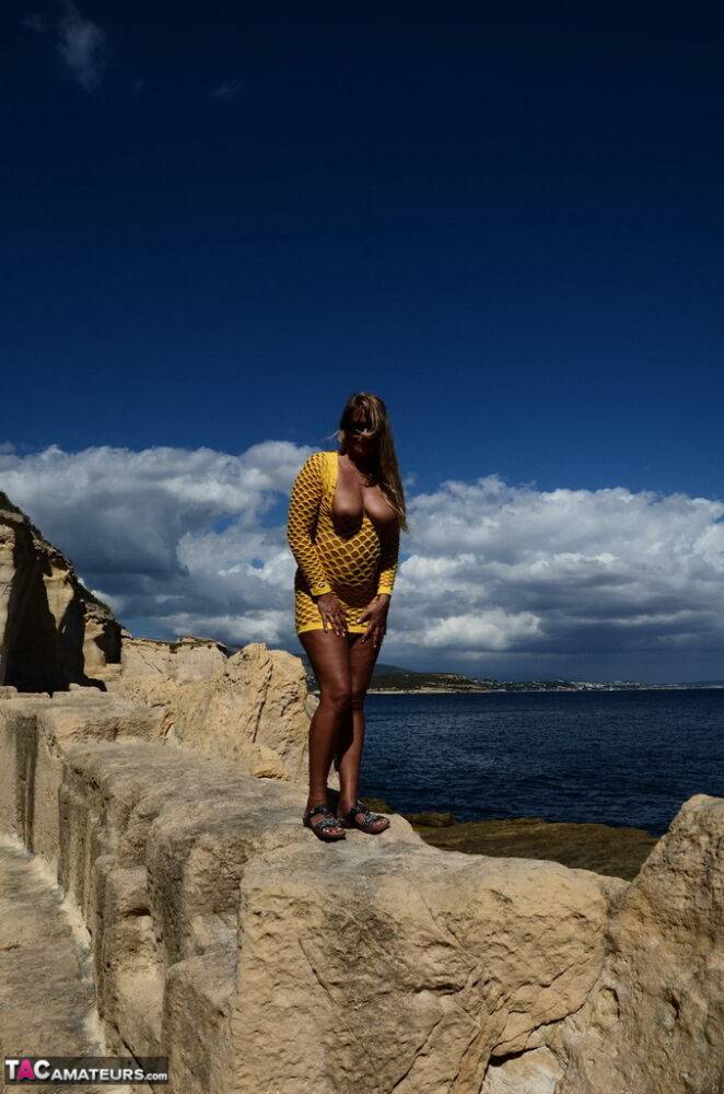 Over 30 blonde Sweet Susi gets naked in shades on a seaside cliff | Photo: 1330744