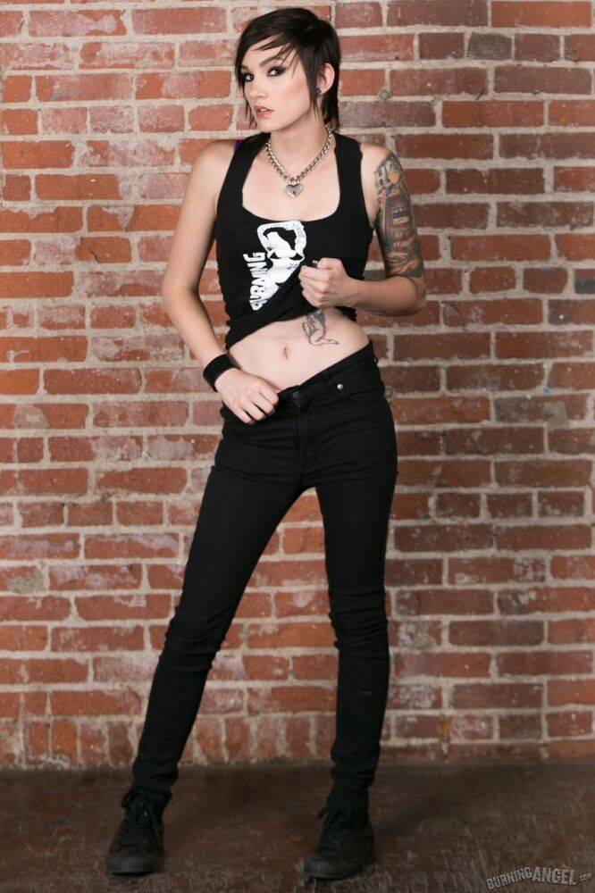 Punk girl Nikki Hearts frees her tattooed body of clothes afore a brick wall - #5