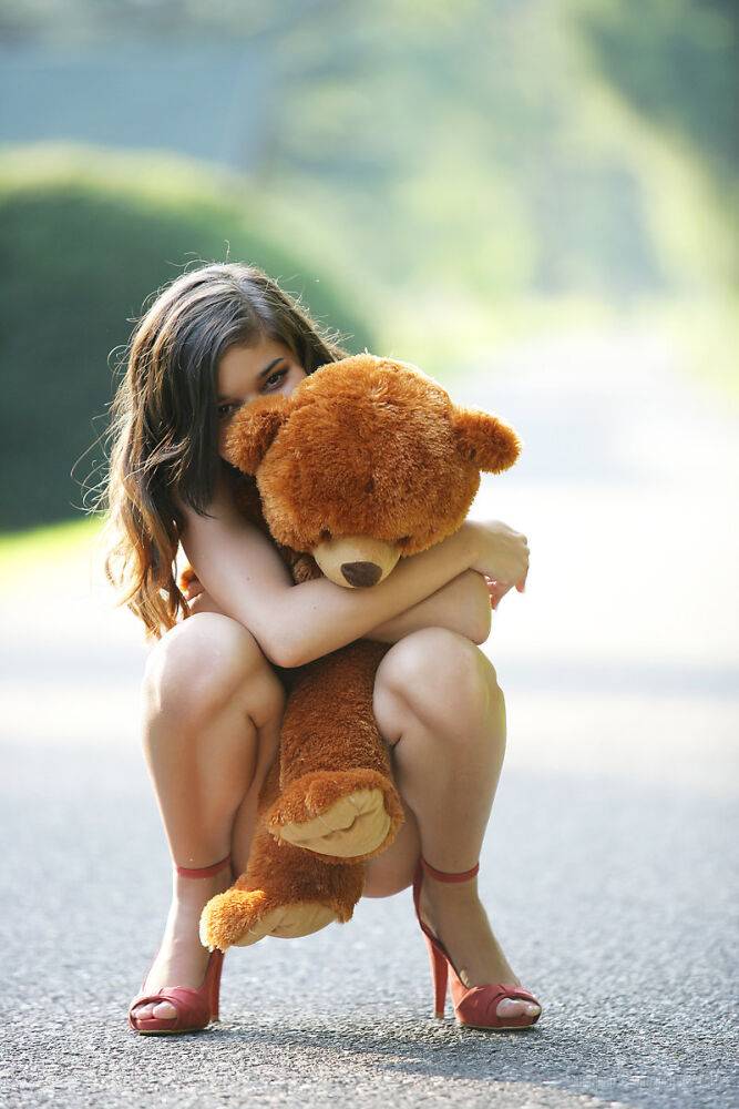 Young looking teen Nika poses naked on a road with a stuffed bear - #8