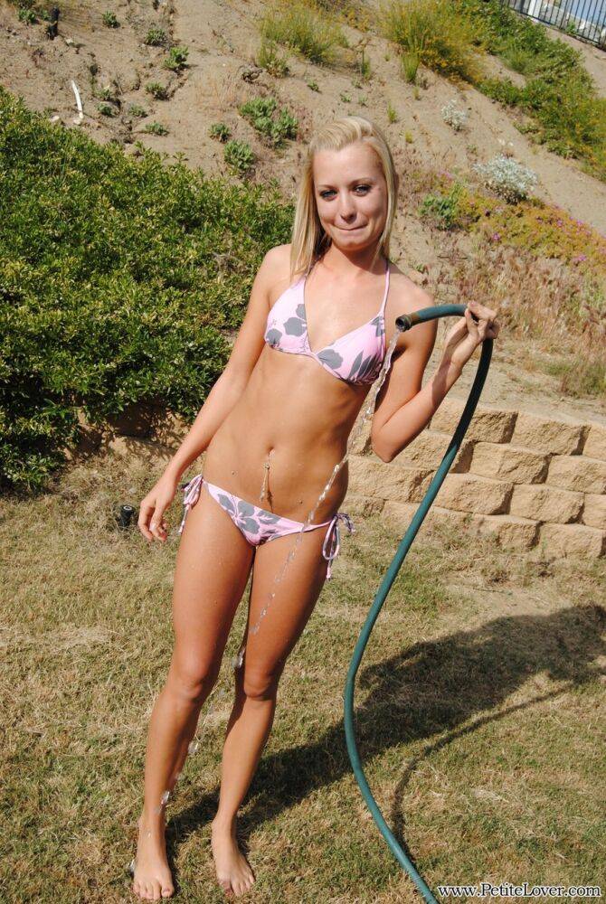 Young blonde girl in a bikini soaks herself with a garden hose - #11