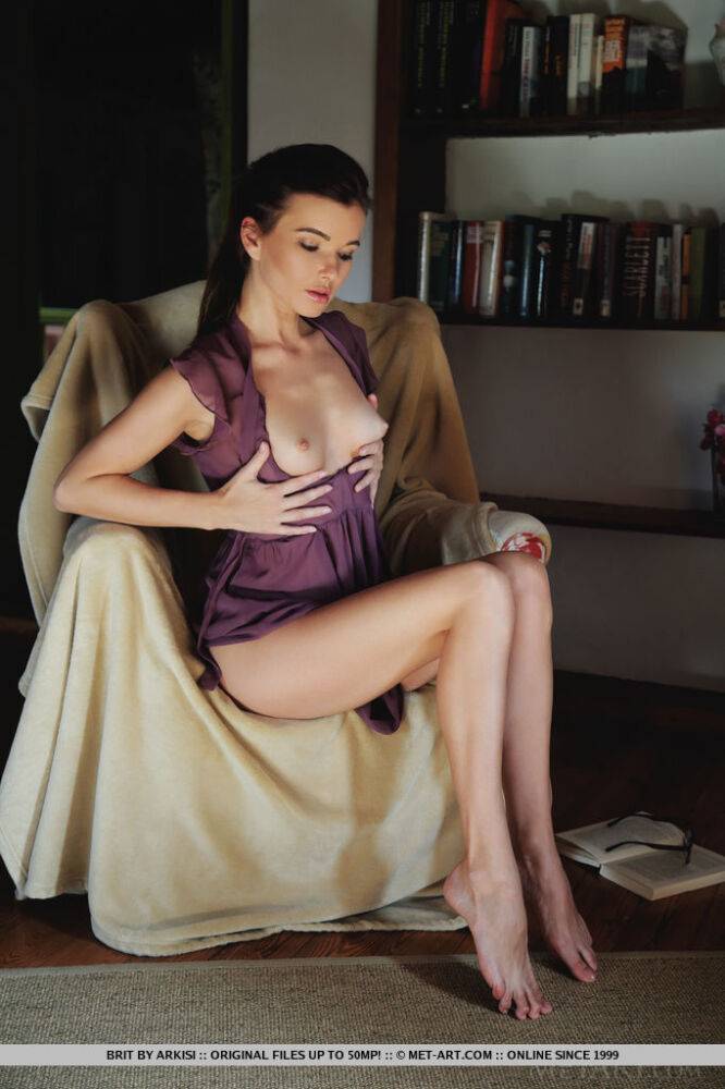 Thin teen takes off her glasses before modeling naked after reading in a chair - #5