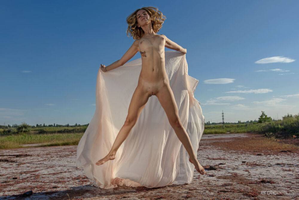 Blonde teen Artemida models totally naked in a wide open field - #12