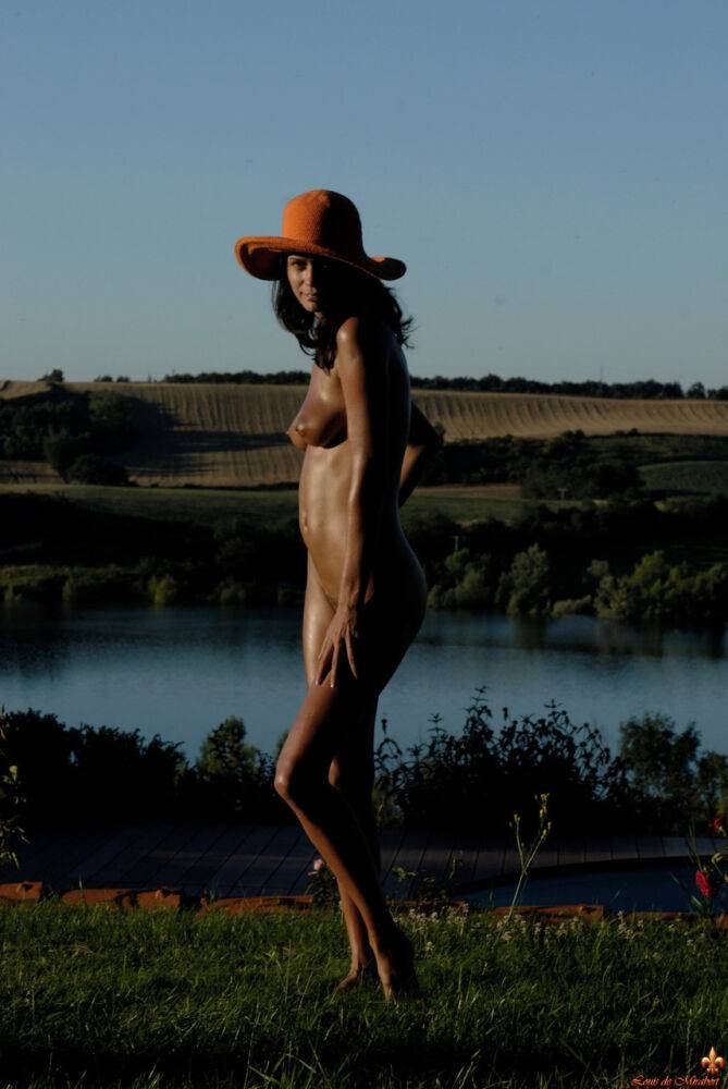 Beautiful brunette Marie models naked near a river in a hat - #16