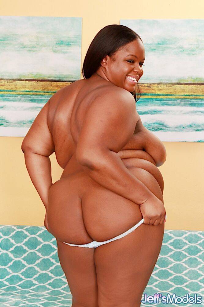 Obese black lady Olivia Leigh holds her big ass after getting naked on a futon | Photo: 2712040