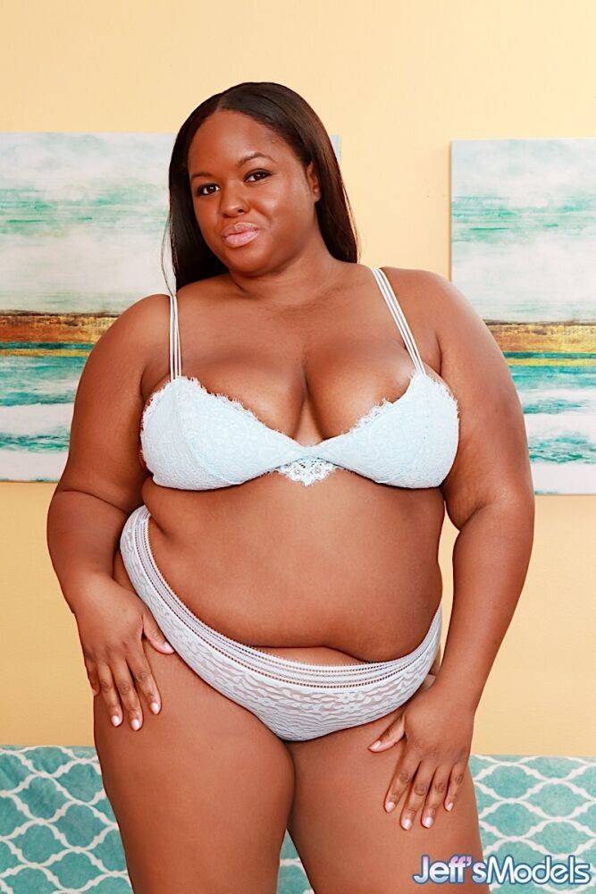 Obese black lady Olivia Leigh holds her big ass after getting naked on a futon | Photo: 2712002
