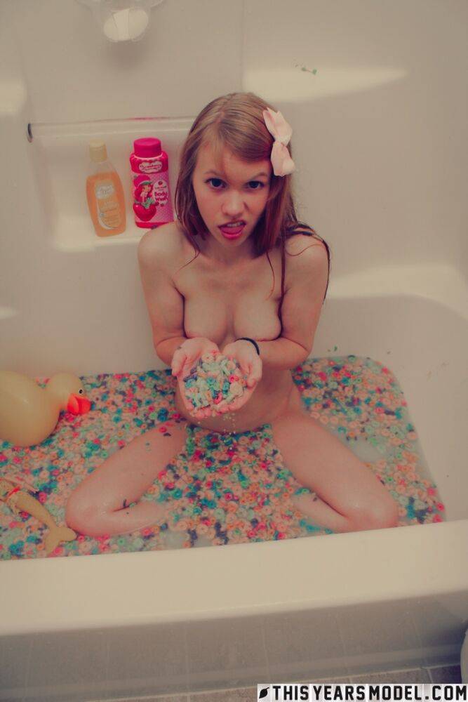 Young looking girl Dolly Little empties a box of cereal into her bathwater - #14