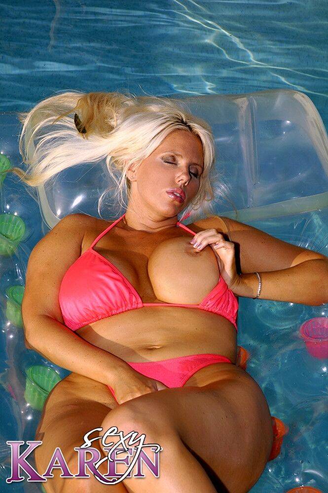 Karen lounging on a raft in a pool in a hot pink bikini - #2