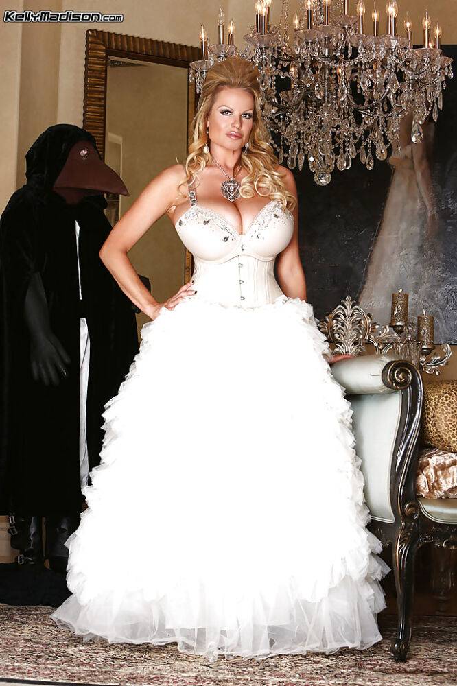 Kelly Madison is posing in a sexy wedding dress and white stockings | Photo: 3673343