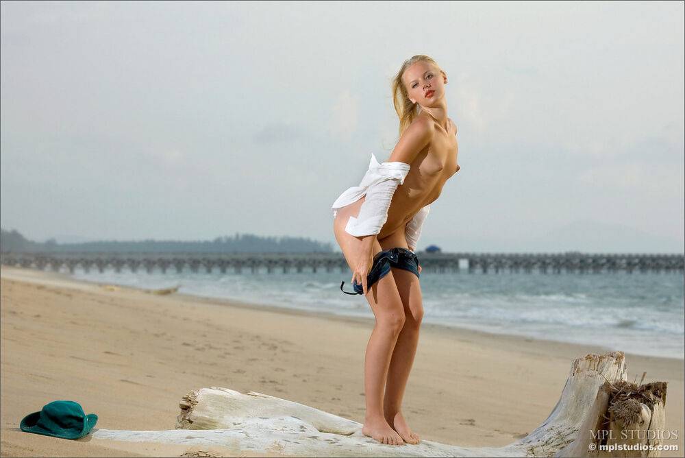 Barefoot blonde removes a white blouse to go totally naked on a sandy beach - #10