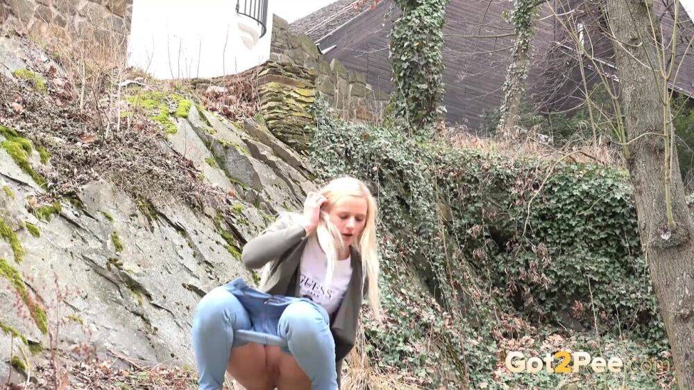 Young girl with long blonde hair Katy Sky pulls down her jeans to pee outside | Photo: 3824061