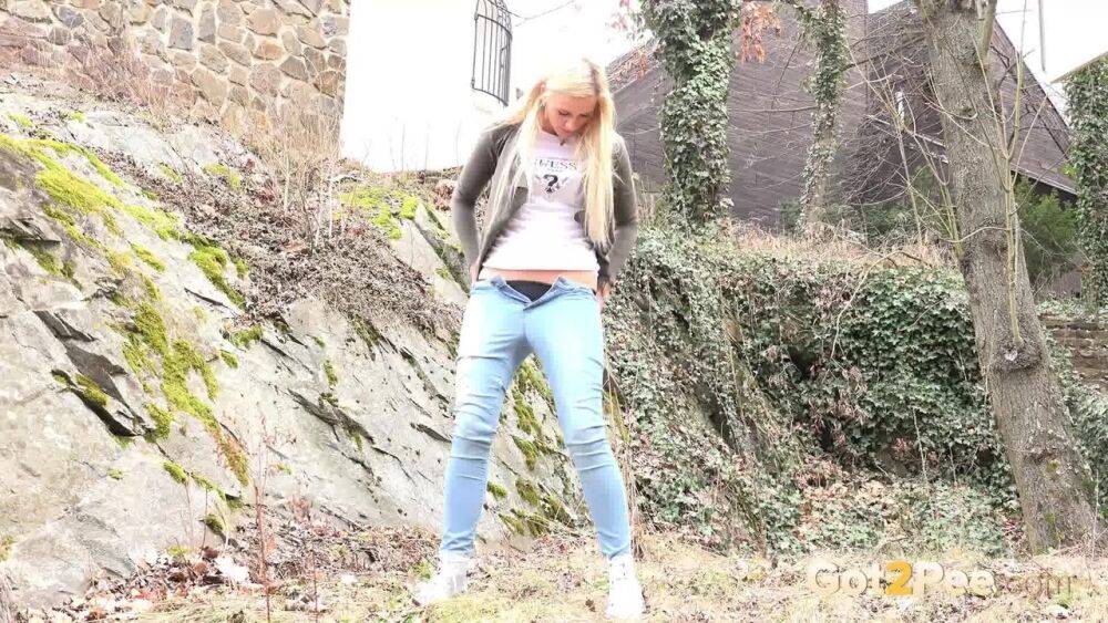 Young girl with long blonde hair Katy Sky pulls down her jeans to pee outside | Photo: 3824038