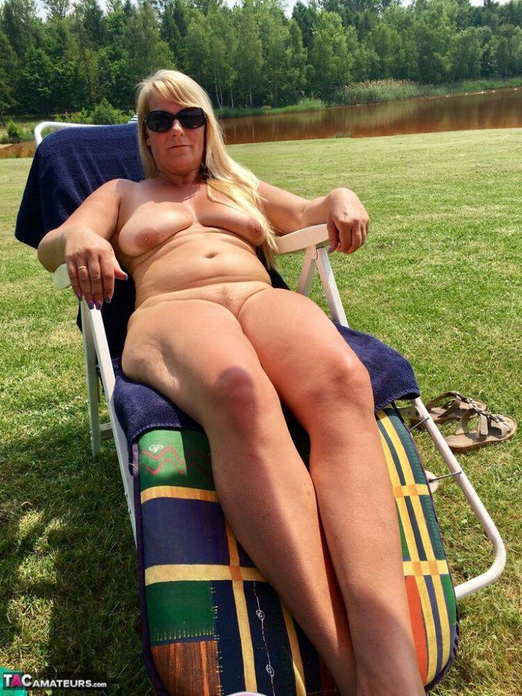Overweight blonde amateur sunbathes with shades on down by the river - #2