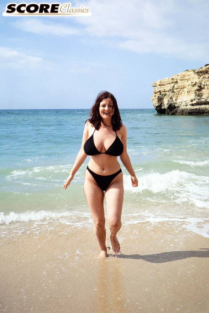 Brunette MILF Lorna Morgan releases her nice melons from bikini on a beach - #9