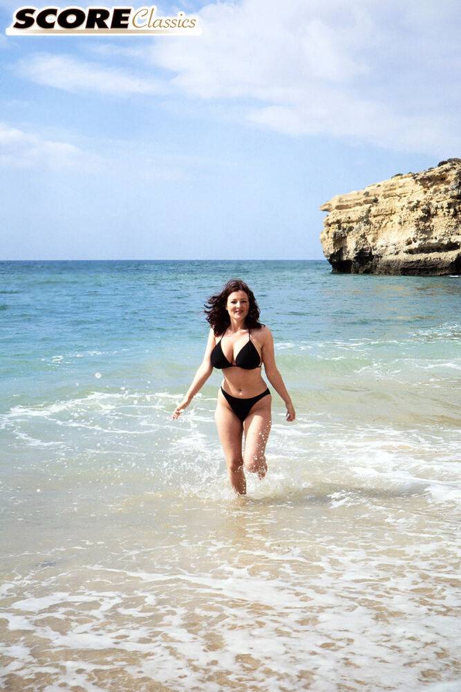 Brunette MILF Lorna Morgan releases her nice melons from bikini on a beach - #8