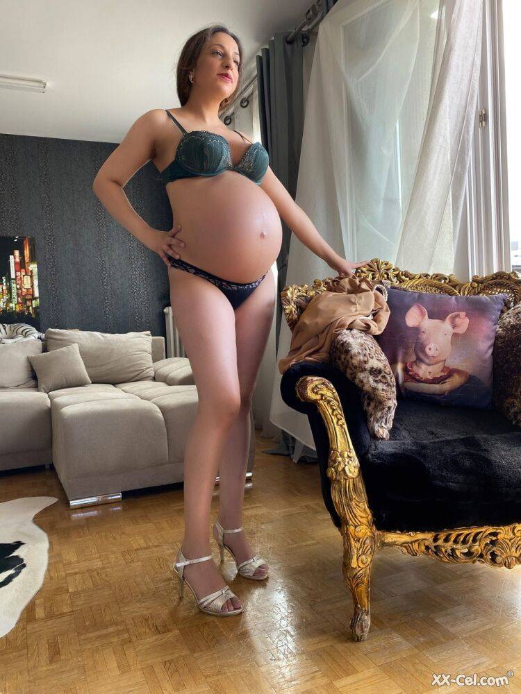 Pregnant smoker Leila teasing nude with her bulging tummy & her dark nipples | Photo: 4003077