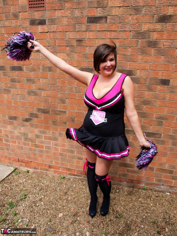 Chubby cheerleader Roxy uncovers her large tits against a brick wall - #15