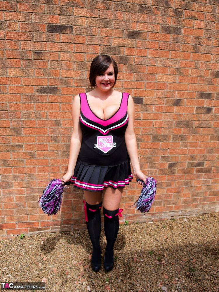 Chubby cheerleader Roxy uncovers her large tits against a brick wall - #4