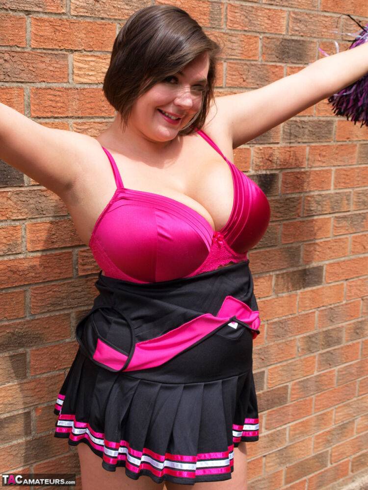 Chubby cheerleader Roxy uncovers her large tits against a brick wall - #7