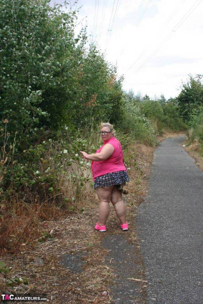 Fat UKwoman Lexie Cummings walks a path sporting a raccoon tail butt plug - #12