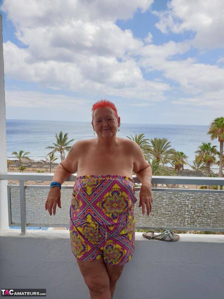 Obese nan with spiky red hair unveils her tits on balcony before posing naked - #16