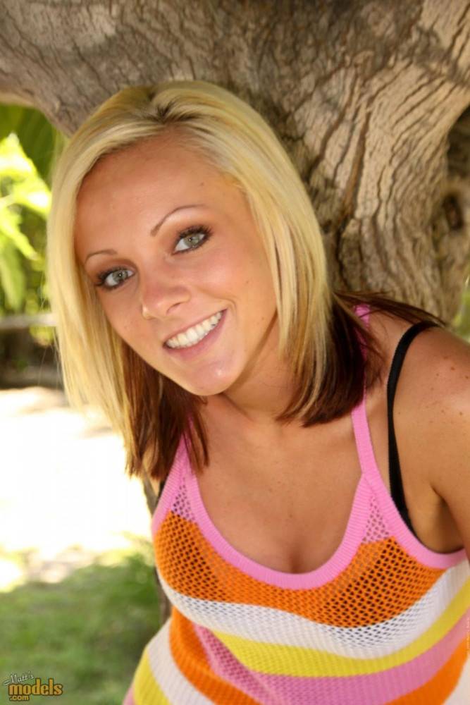 Smiling Blonde Kitty Cali Kayden Shows Her Bald Pussy In The Shadow Of A Tree - #1