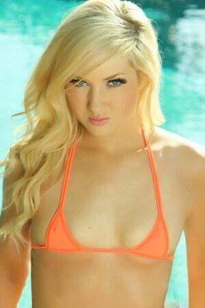 Petite blonde Ashlie Madison models non nude in skimpy bikini by pool on nudepicso.com