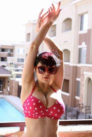 Amateur girl Susy Rocks models a polka-dot bikini in shades on a balcony on nudepicso.com