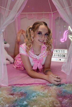 Cute teen Lily Larimar plays with her curly pigtails while getting naked on nudepicso.com