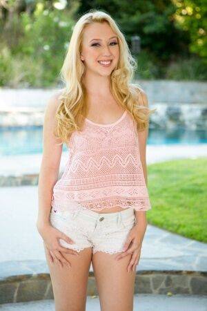 Cute blonde Samantha Rone stands naked after disrobing on a backyard walkway on nudepicso.com