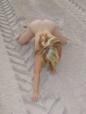 Mature blonde Sweet Susi doffs a bikini to pose naked in a sand pit on nudepicso.com