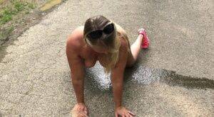 Blonde amateur Sweet Susi takes a piss while naked on a paved road on nudepicso.com