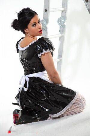 Dark-haired beauty Jasmine Jones models a latex maid uniform in sexy stockings on nudepicso.com