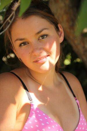 Petite amateur Allie Haze shows her tan lined body in the shade of a tree on nudepicso.com