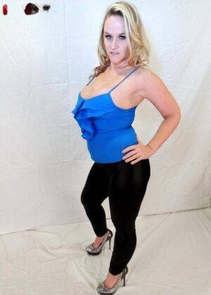 Blonde amateur Dee Siren shows her ample cleavage in black leggings on nudepicso.com