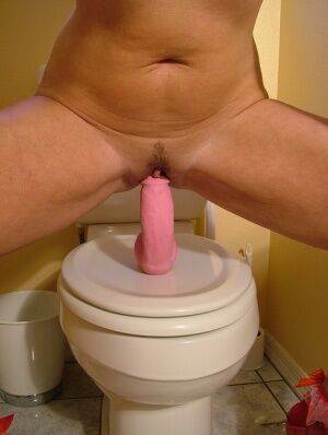 Older amateur Dee Delmar rides her pink dildo on top of toilet seat on nudepicso.com