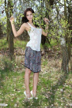Long legged Michaela Isizzu flashes naked upskirt and poses nude in the forest on nudepicso.com