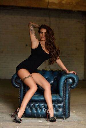 Tattooed model Gemma Massey works clear of a black dress to pose nude in heels on nudepicso.com