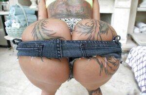 Tattooed solo model Bella Bellz showing off inked butt and bald cunt on nudepicso.com