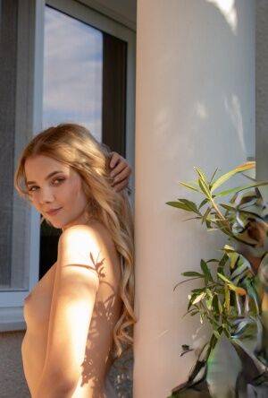 Young blonde Chanel Fenn shows her sexy ass while getting naked in a garden on nudepicso.com