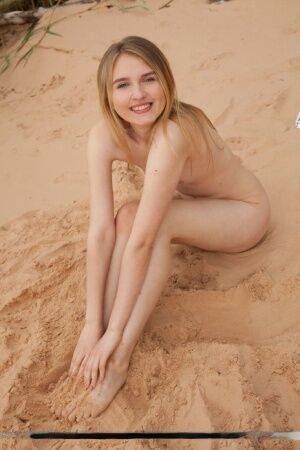 Cute teen girl Lia Kate gets totally naked on a sandy beach on nudepicso.com